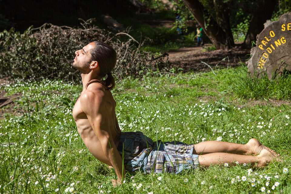 A man doing yoga outdoors.