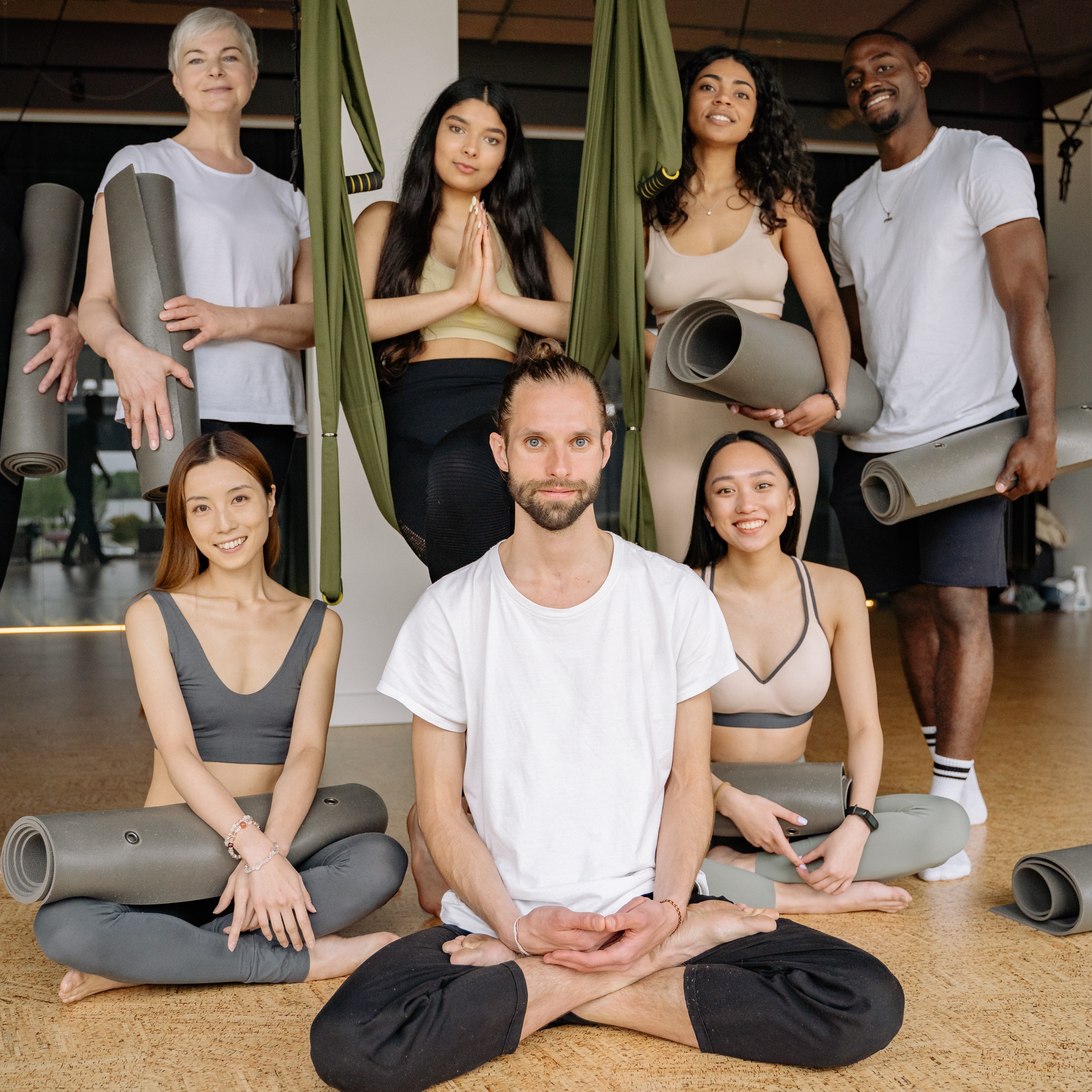 group of people of different races and ages with yoga mats