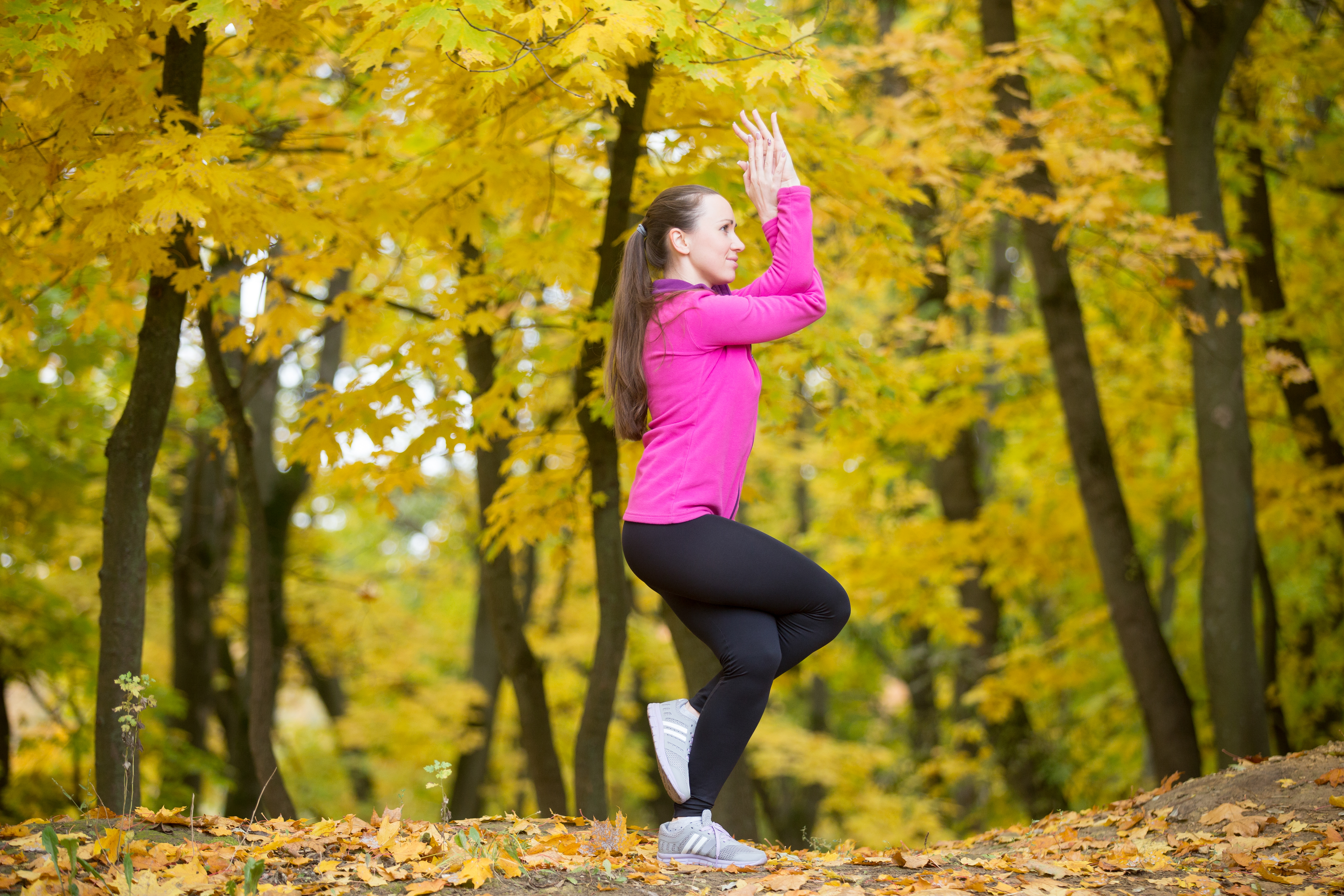 woman doing the eagle pose in an outdoor space